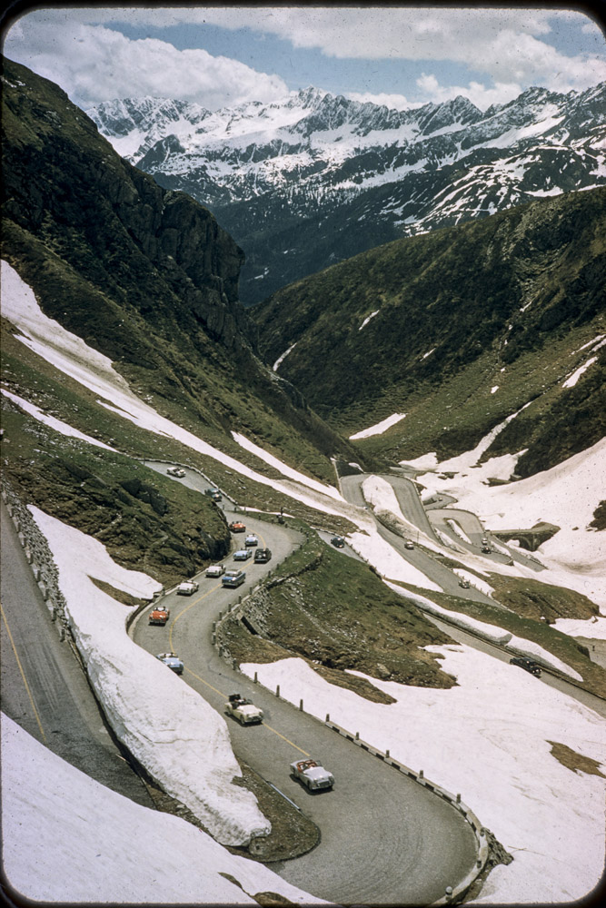 Alps, cars, roads, snow covered mountains
